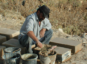 Making cement bricks for the four-room house