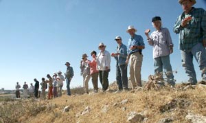 Part of the `Umayri-2002 excavation team, lined up along the northern edge of the tell, following the inaugural slaughter of the watermelon at second breakfast on our first day. Photo Larry Murrin)