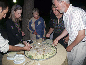 Hungry Group Gathers around One of Several Platters Piled High with Rice, Pine Nuts, Goat Meat and Yoghurt Sauce
