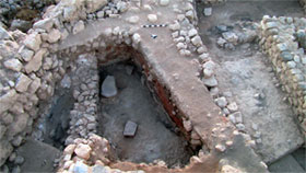 Field A--Early Iron 1 building with huge grinding stone and exposed floor and walls