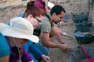 Newcomers to the dig learn the basic technique of using a pick & trowel. 