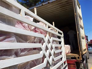Wrapped crates being off-loaded into container